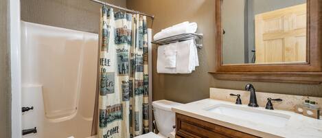 A bathroom with a bathtub, toilet, and sink.