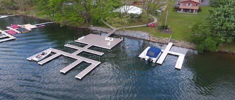 A lakeside dock with several boats and a covered boat ramp.