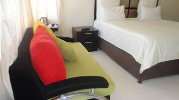 Una habitación de hotel con una cama, una mesita de noche, un escritorio y una silla.