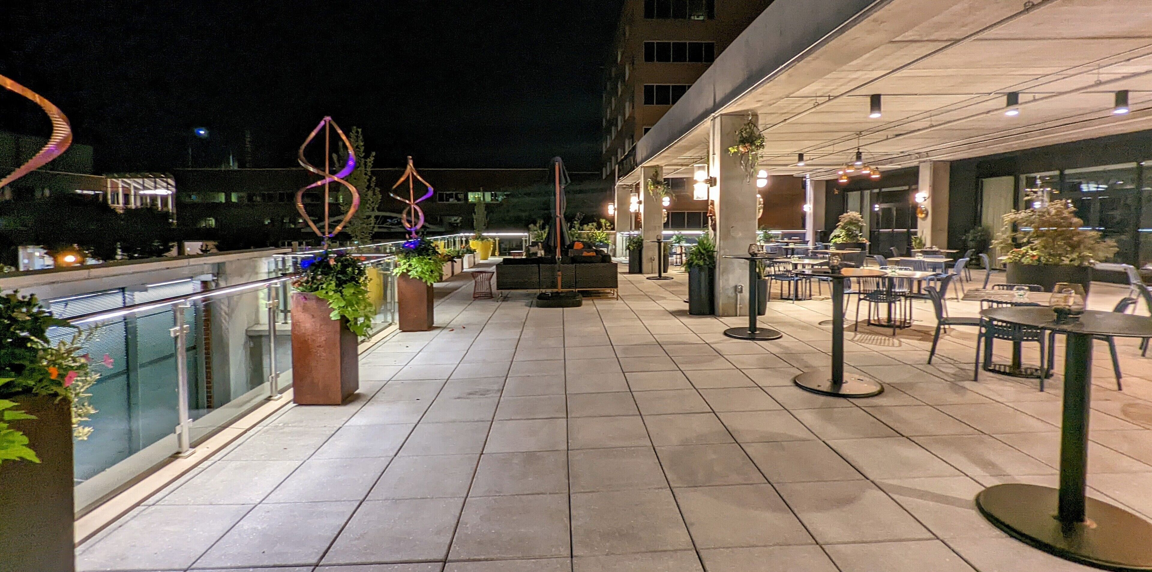 An outdoor terrace with seating, potted plants, and decorative elements.