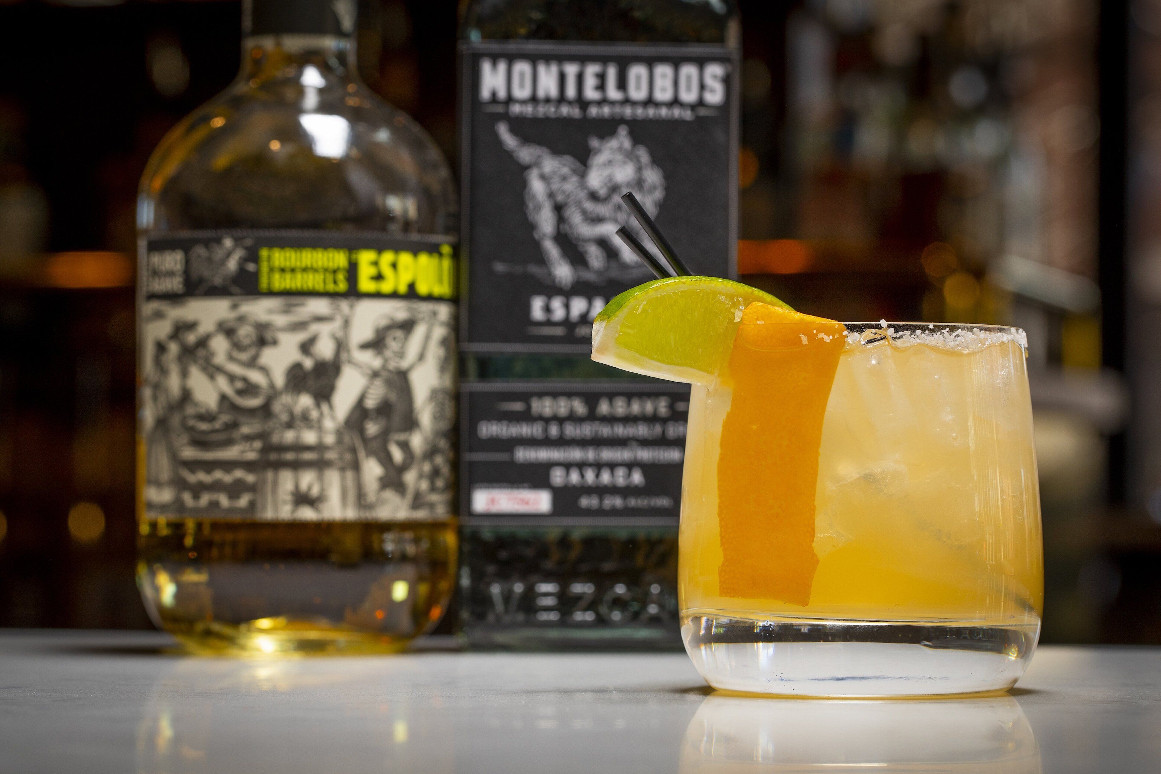 A bar setting with a cocktail glass and two bottles of liquor.