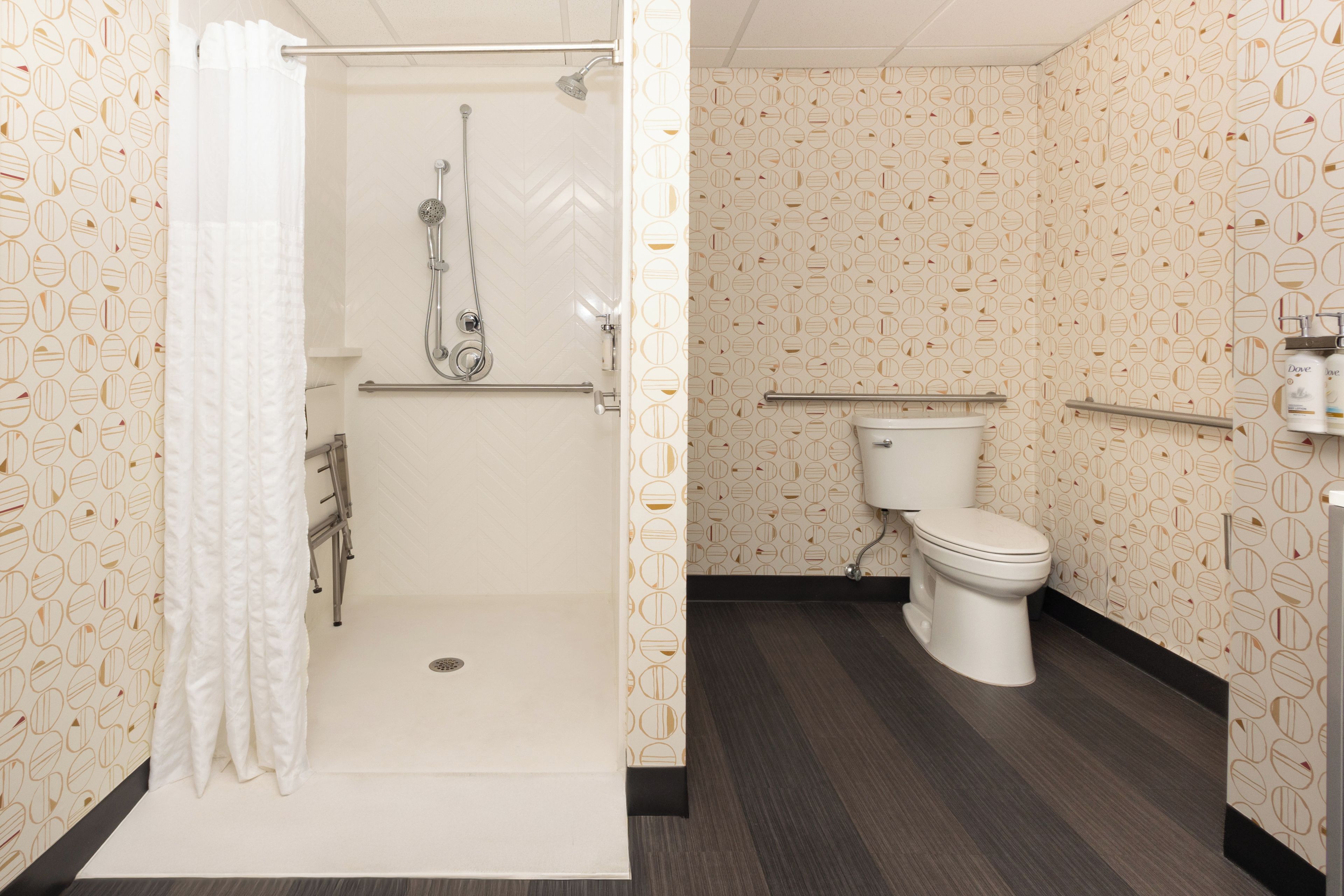 A bathroom with a shower, toilet, and a towel rack.