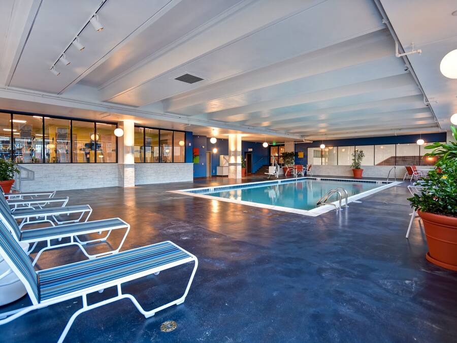 A spacious indoor pool area with lounge chairs and a clear view of the pool.