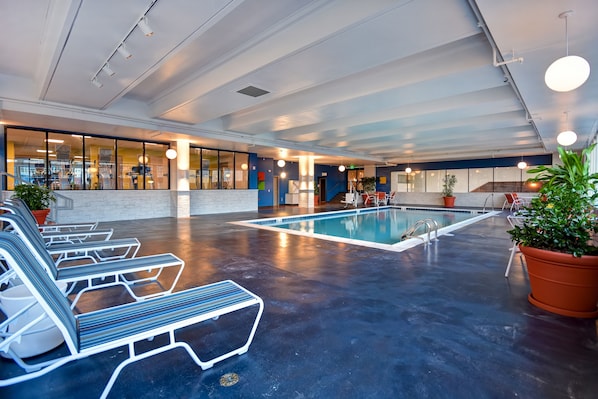 A spacious indoor pool area with lounge chairs and a clear view of the pool.