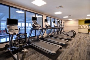 A gym with treadmills, exercise bikes, and a weight machine.