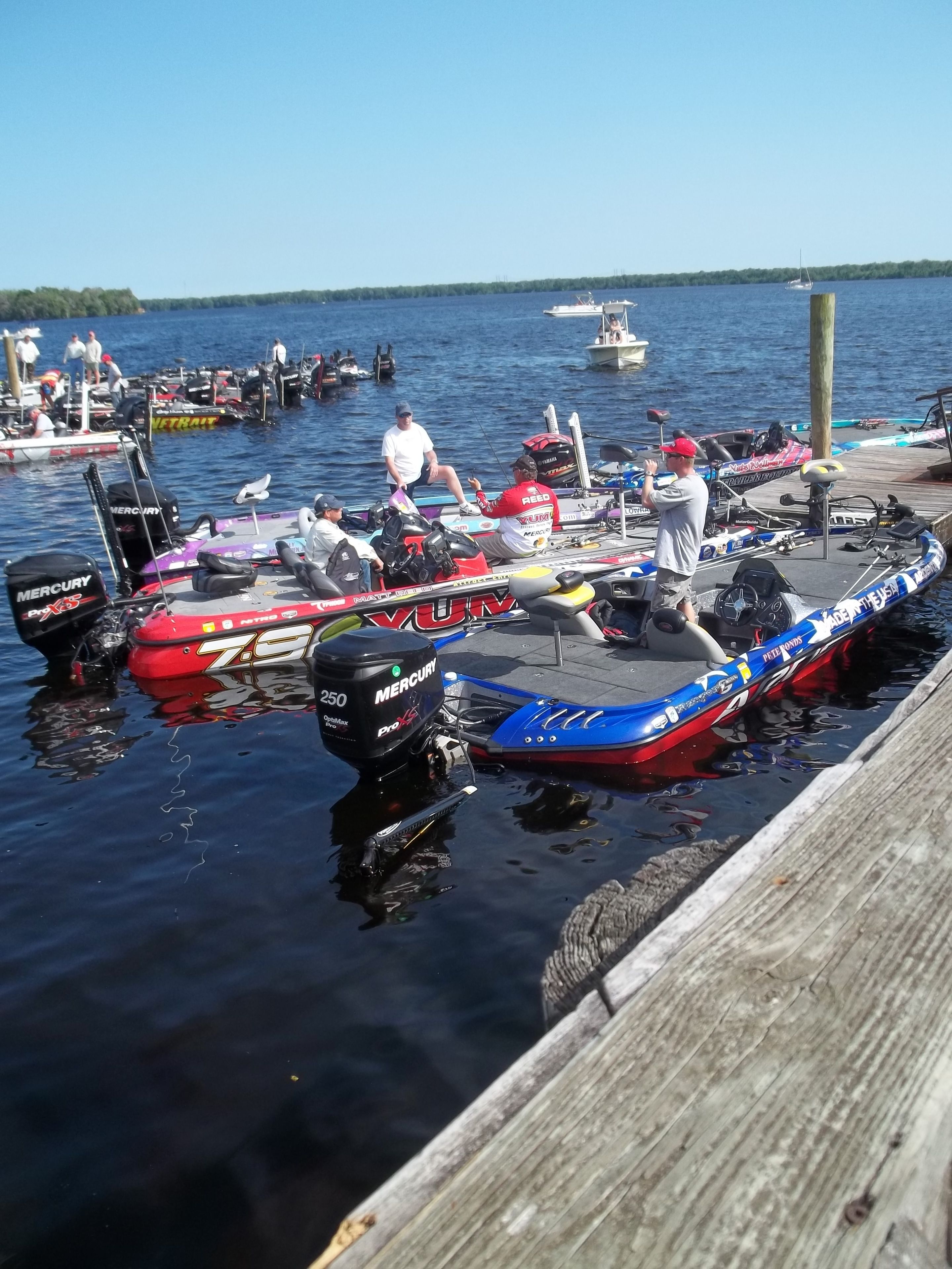 A dock with several boats, including a red and a blue one, and a wooden pier.