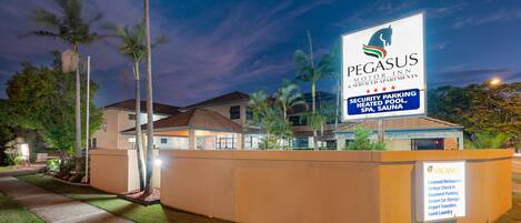 A Pegasus Motor Inn signboard with amenities like security parking, heated pool, SPA, and sauna.
