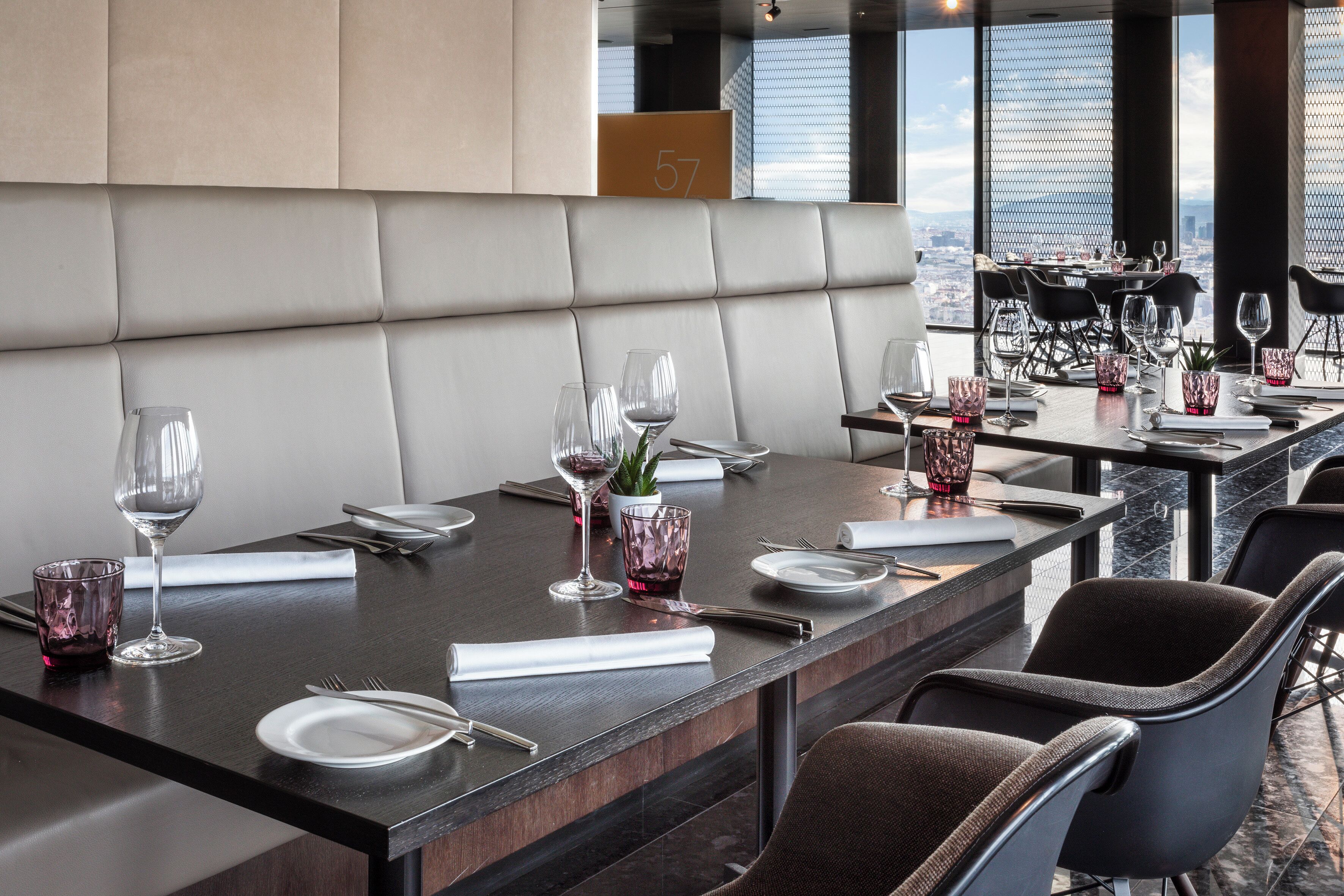 A modern dining area with leather booths and tables set for a meal.