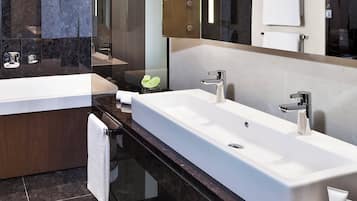 Ein modernes Badezimmer mit zwei großen Waschbecken, einer Badewanne und einem großen Spiegel.
