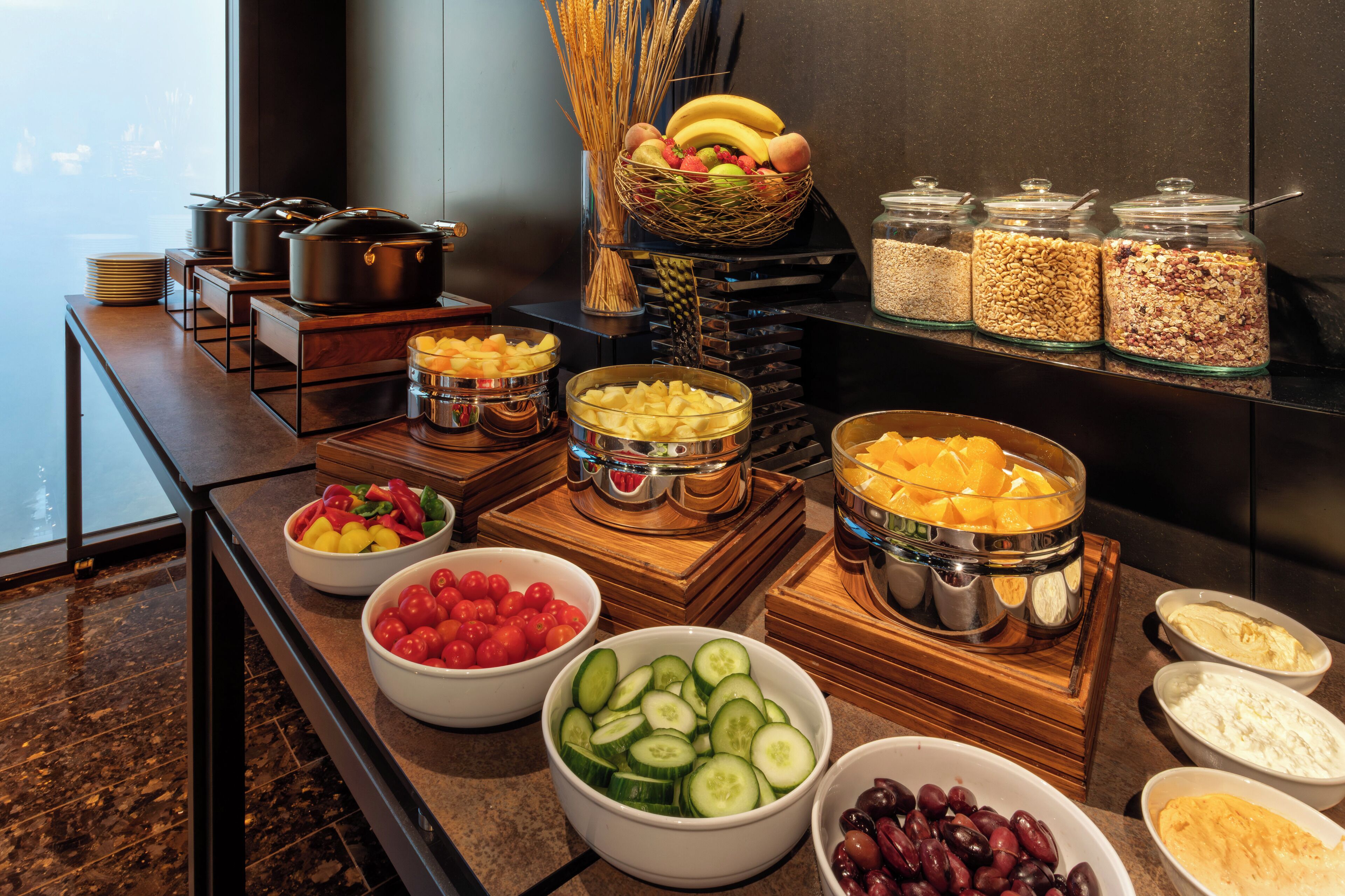 Ein Buffet mit verschiedenen Speisen, darunter Obst, Gemüse und Getreide.