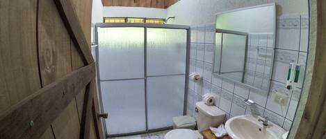 A small bathroom with a toilet, sink, and mirror.