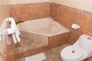 A bathroom with a bathtub, toilet, and a shower area. - Arenal Oasis (La Fortuna)