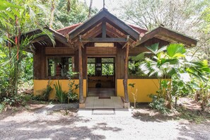 A wooden reception building with a sign, surrounded by tropical vegetation. - Arenal Oasis (La Fortuna)