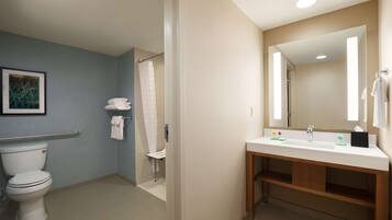 Une salle de bain moderne comprenant des toilettes, une douche et un lavabo.