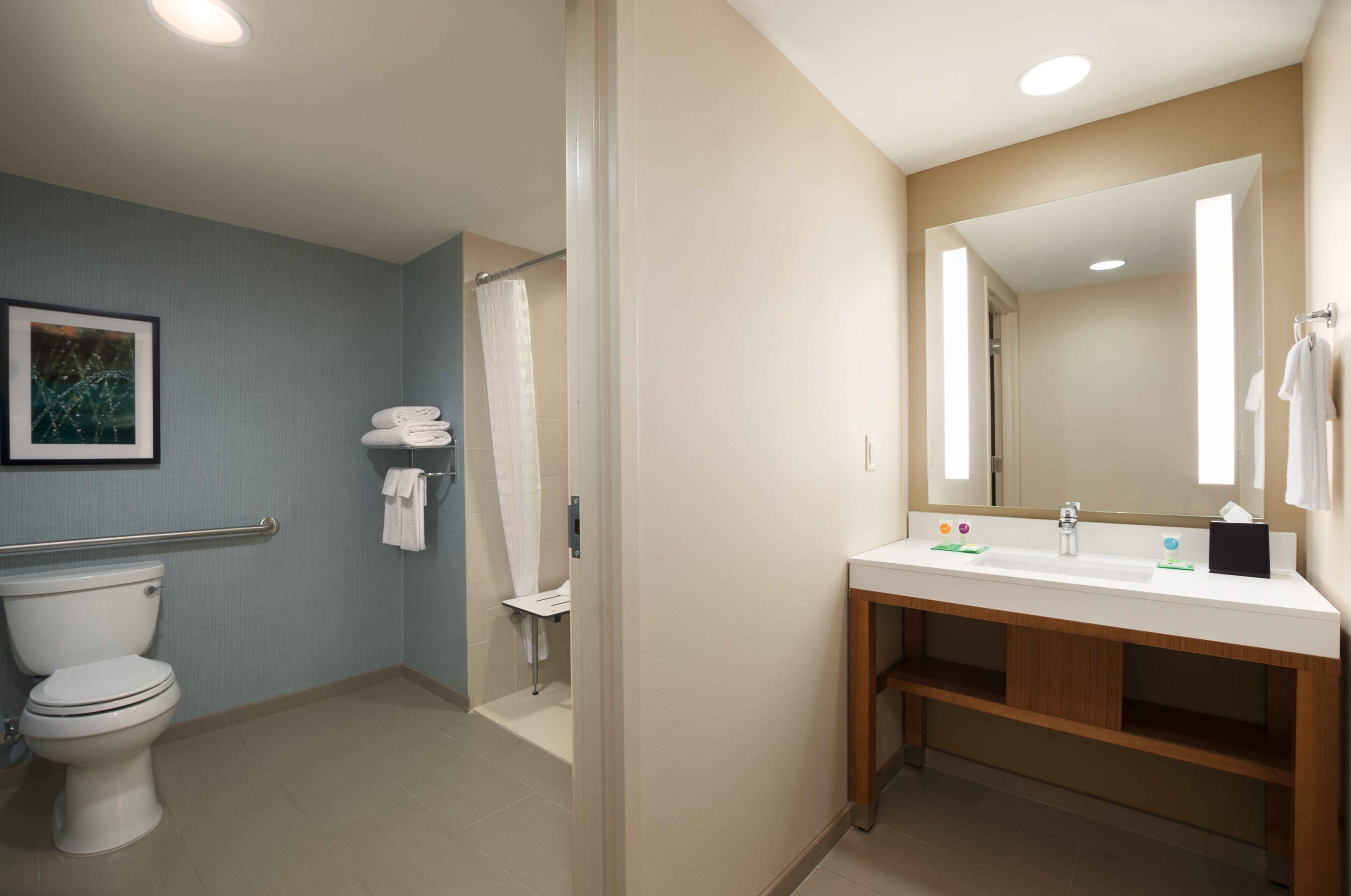 A modern bathroom with a toilet, shower, and sink.