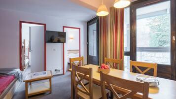 Appartement 6 personnes - 2 chambres | Woonruimte | Een televisie, een tafeltennistafel en boeken