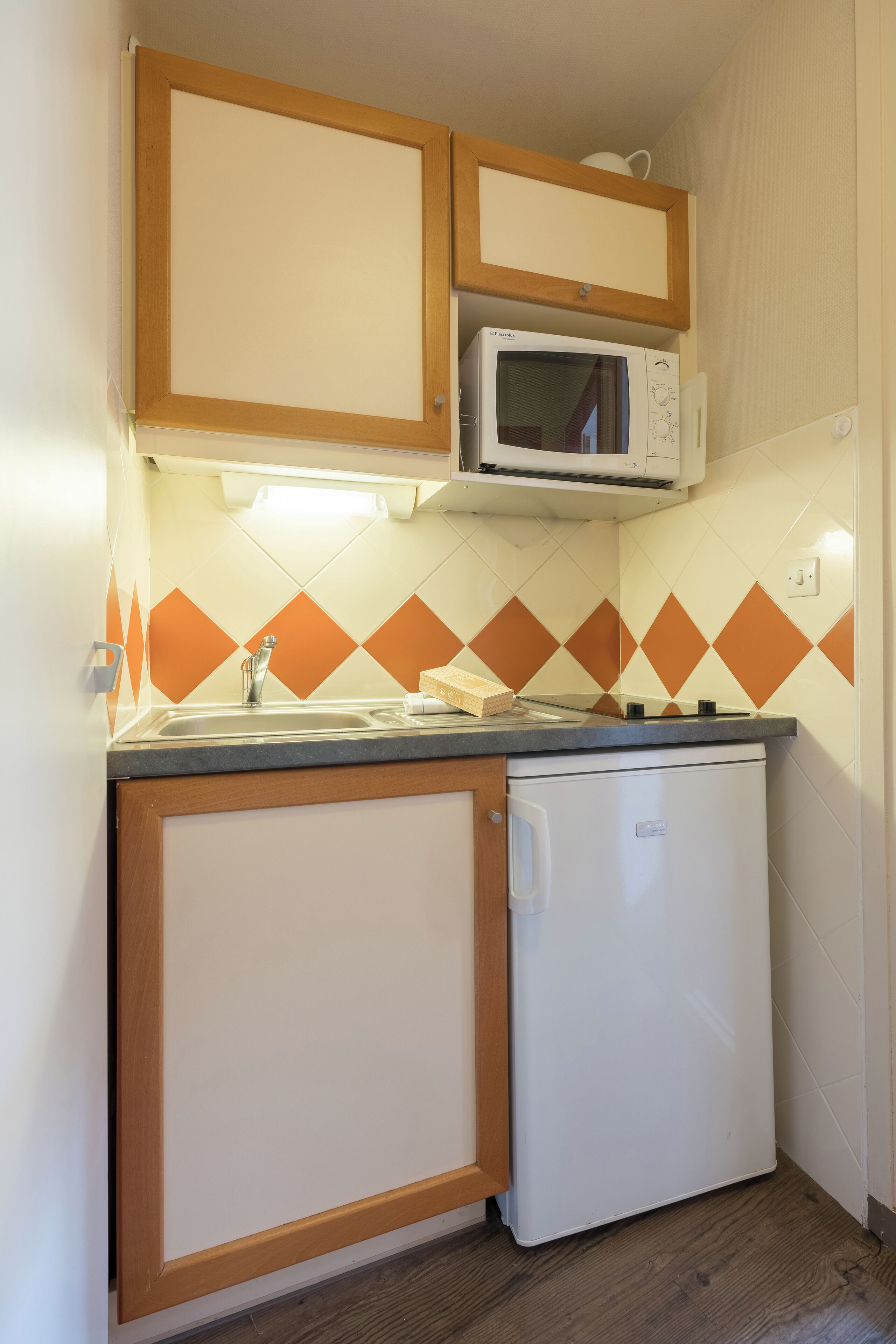 A compact kitchen with a microwave, a sink, and a dishwasher.