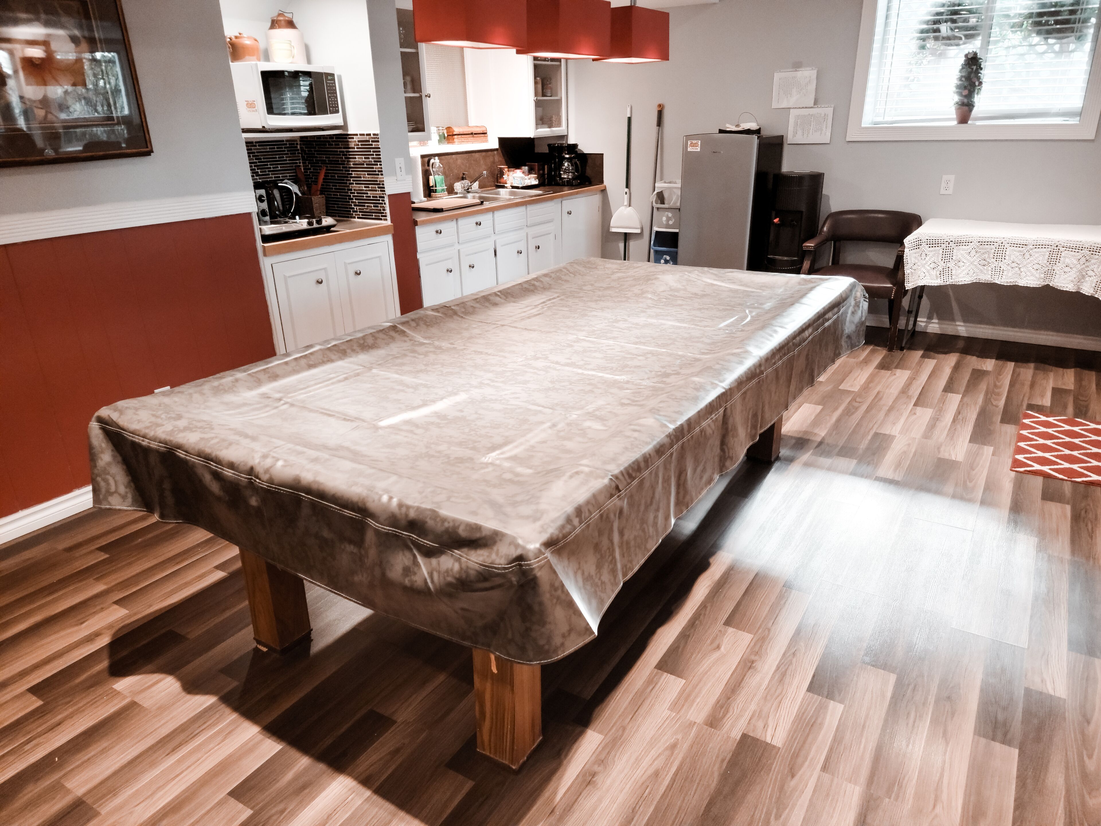 Una habitación con una cama grande, una zona de cocina y una mesa de comedor.