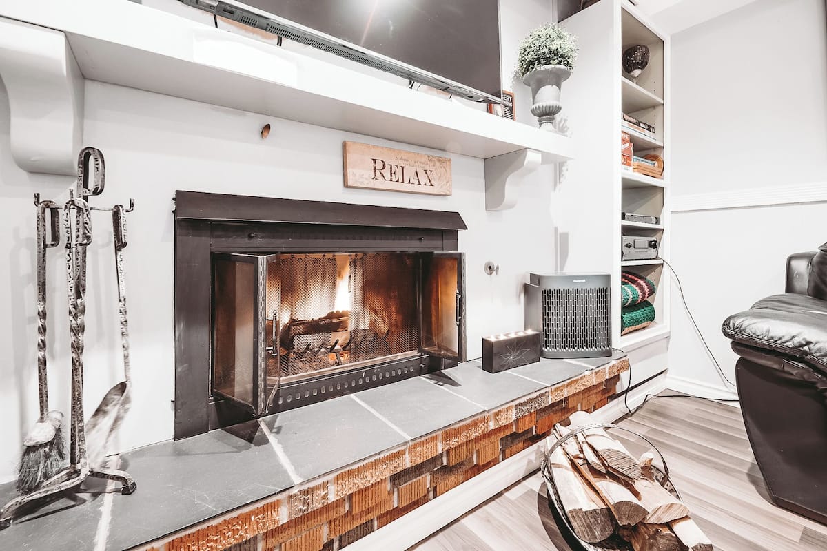 A modern living room with a fireplace, a bookshelf, and a comfortable seating area.