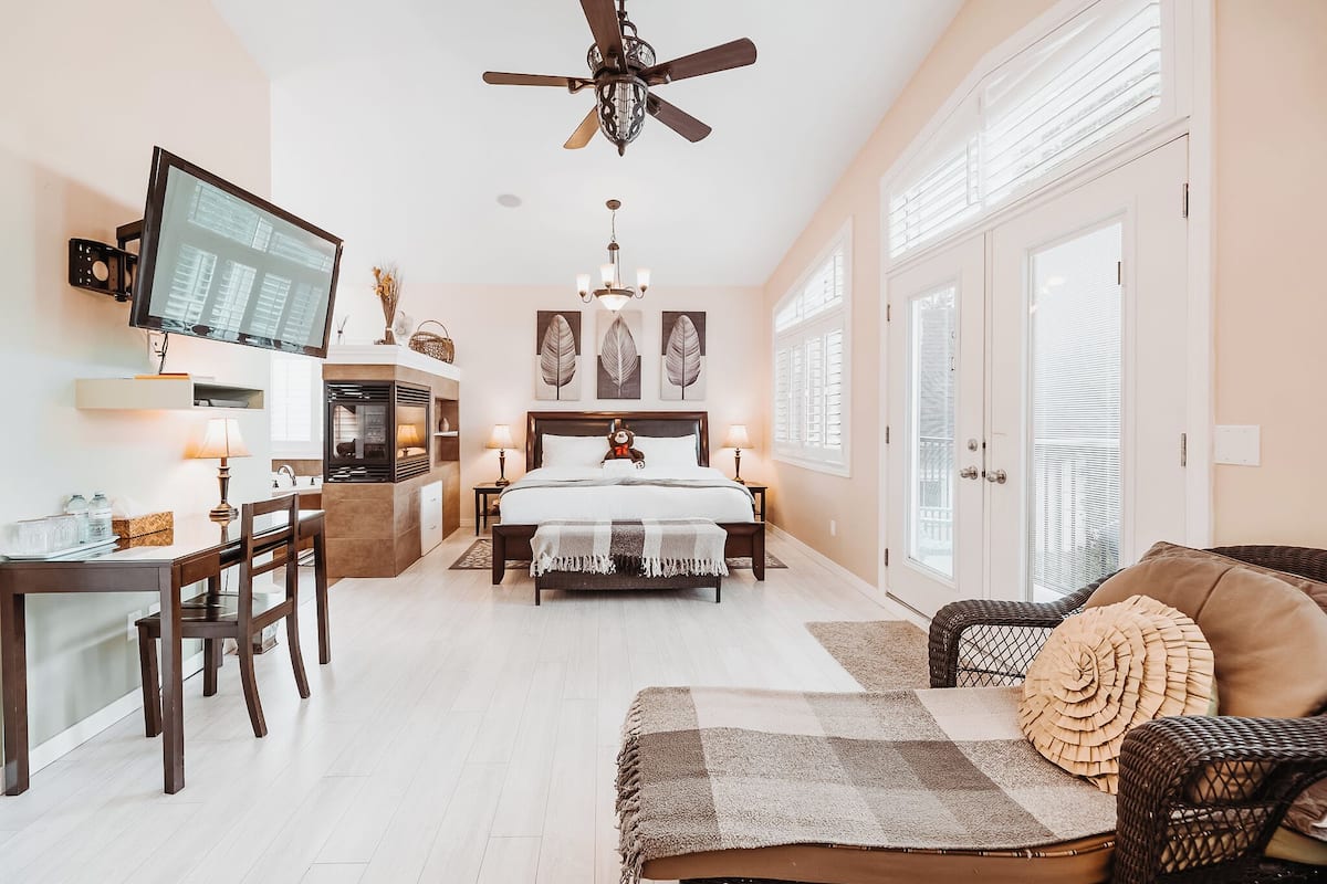 A bedroom with a bed, bedside tables, a desk, and a chair.