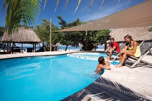 Una piscina al aire libre, sombrillas, tumbonas
