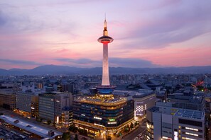 Un hotel moderno con una torre destacada, rodeado de edificios urbanos y un paisaje urbano.