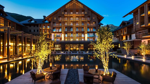 A hotel with a large building, a pool, and outdoor seating. - The Chedi Andermatt (Andermatt)