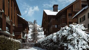 A snow-covered building with wooden balconies and a clear sky.