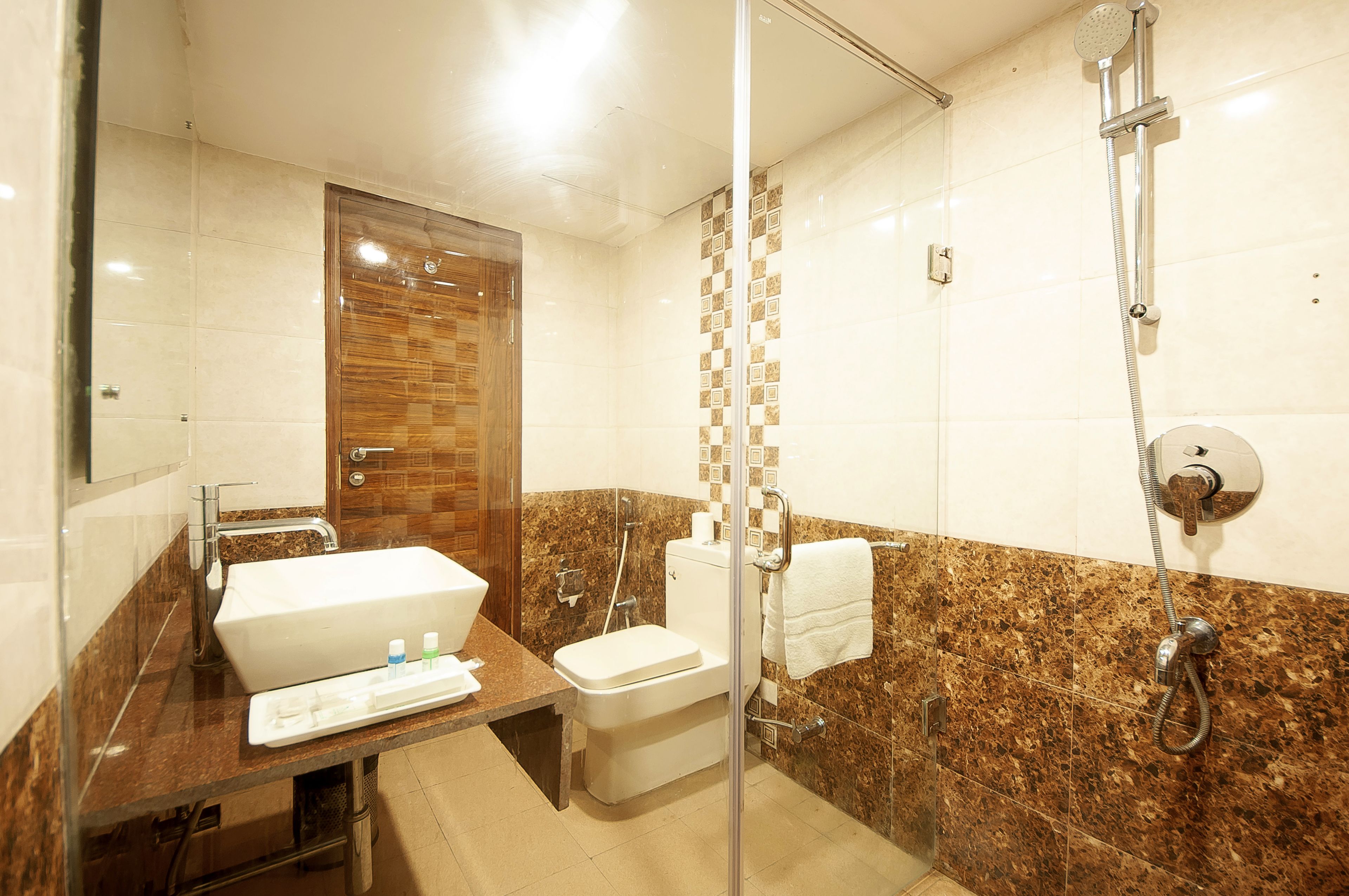 Une salle de bain avec un lavabo en marbre, des toilettes et une douche.