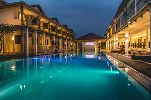 Un hotel con piscina, mobiliario exterior y un cartel que dice "ALIA Resort".