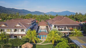 Un resort con varias edificaciones, una piscina y abundante vegetación.