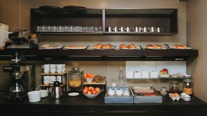 A breakfast buffet setup with various food items, coffee machines, and serving ware. - Hotel Zaragoza Plaza (San Sebastián)