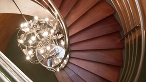 A spiral staircase with wooden steps and a metal handrail. - Hotel Zaragoza Plaza (San Sebastián)
