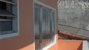 Un edificio con ventana, puerta y un pequeño balcón.