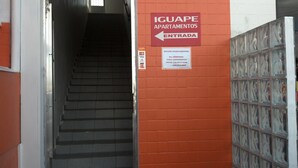 Una escalera que conduce a una entrada con la leyenda 'IGUAPE APARTAMENTOS ENTRADA'.