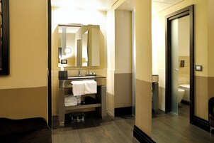 A modern bathroom with a sink, mirror, and toilet.