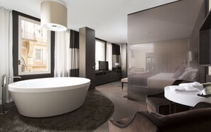 A modern bathroom with a large bathtub, a separate shower area, and a vanity with a mirror.