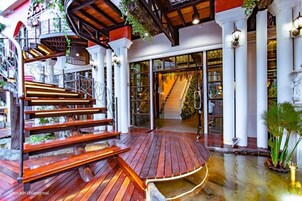 Un escalier en bois mène à une zone abritée d’où l’on peut voir l’entrée d’un bâtiment.
