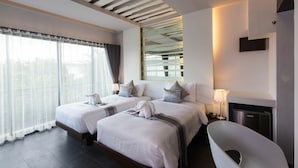 Una habitación de hotel moderna con dos camas, un ventanal grande con cortinas, una bañera integrada y un diseño de techo único.