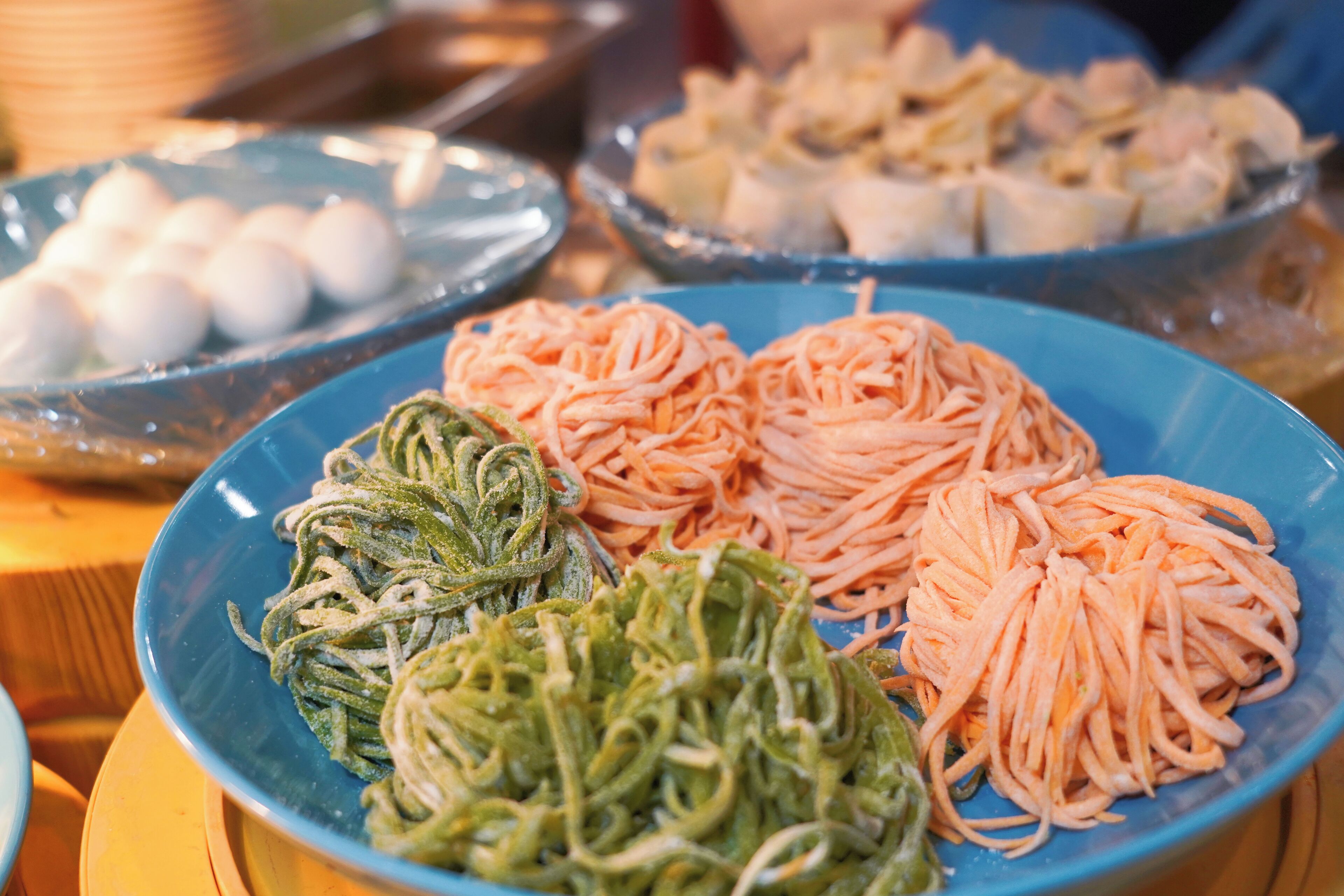 Un bufé con diversos platos, incluyendo fideos y otras opciones de comida.