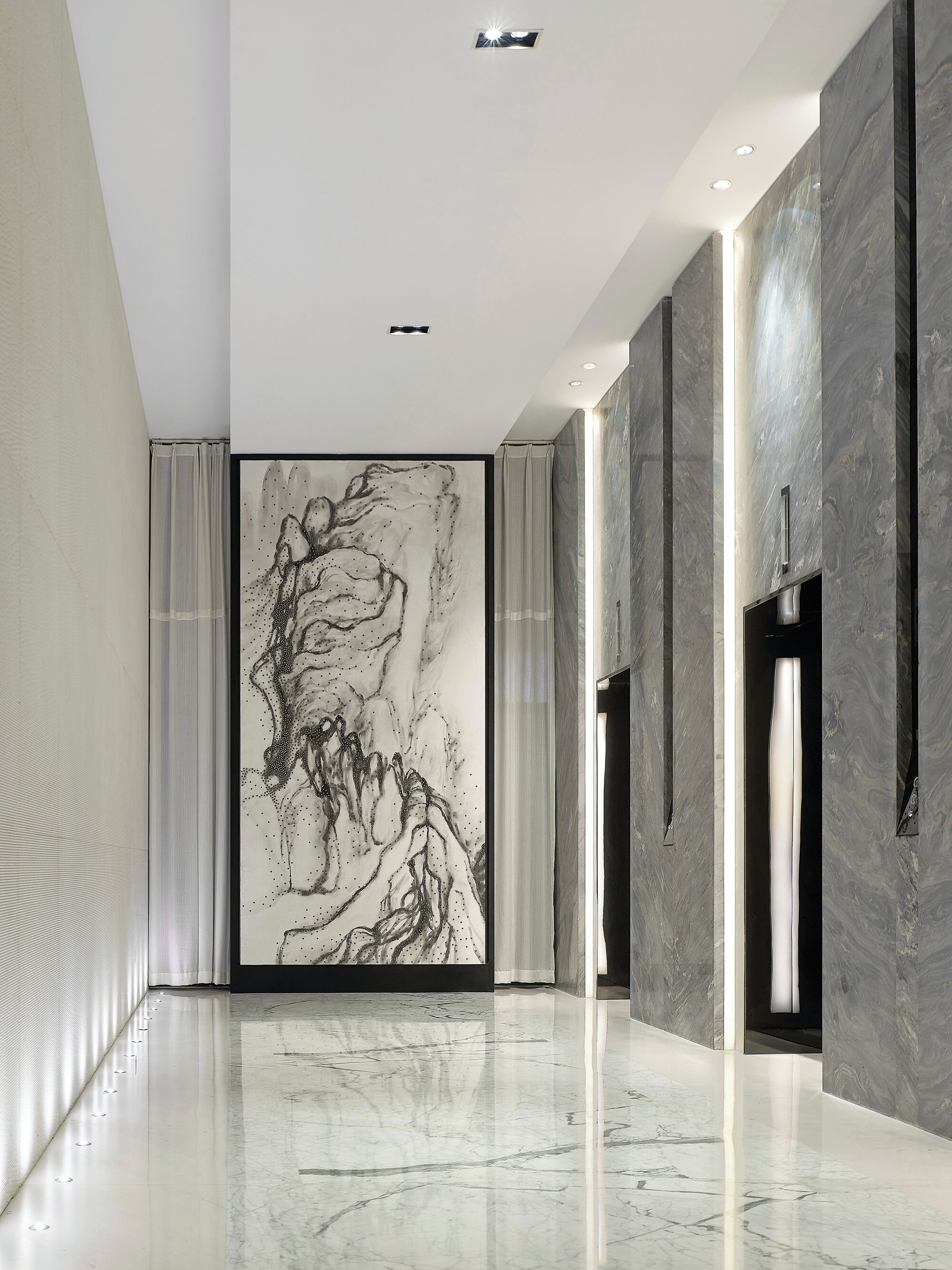 Un pasillo moderno con suelo de mármol, una gran obra de arte abstracta y una puerta con pomo.