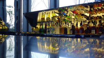 A bar with a variety of liquor bottles displayed on shelves and hanging from the ceiling.