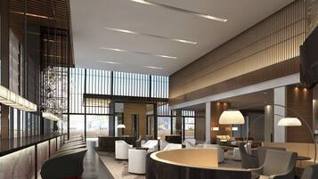 A modern lobby with a curved reception desk, seating areas, and large windows.