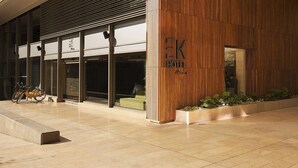 A modern hotel with a wooden facade, large windows, and a bicycle parked outside. - EK Hotel By Preferred Hotels Group (Bogotá)