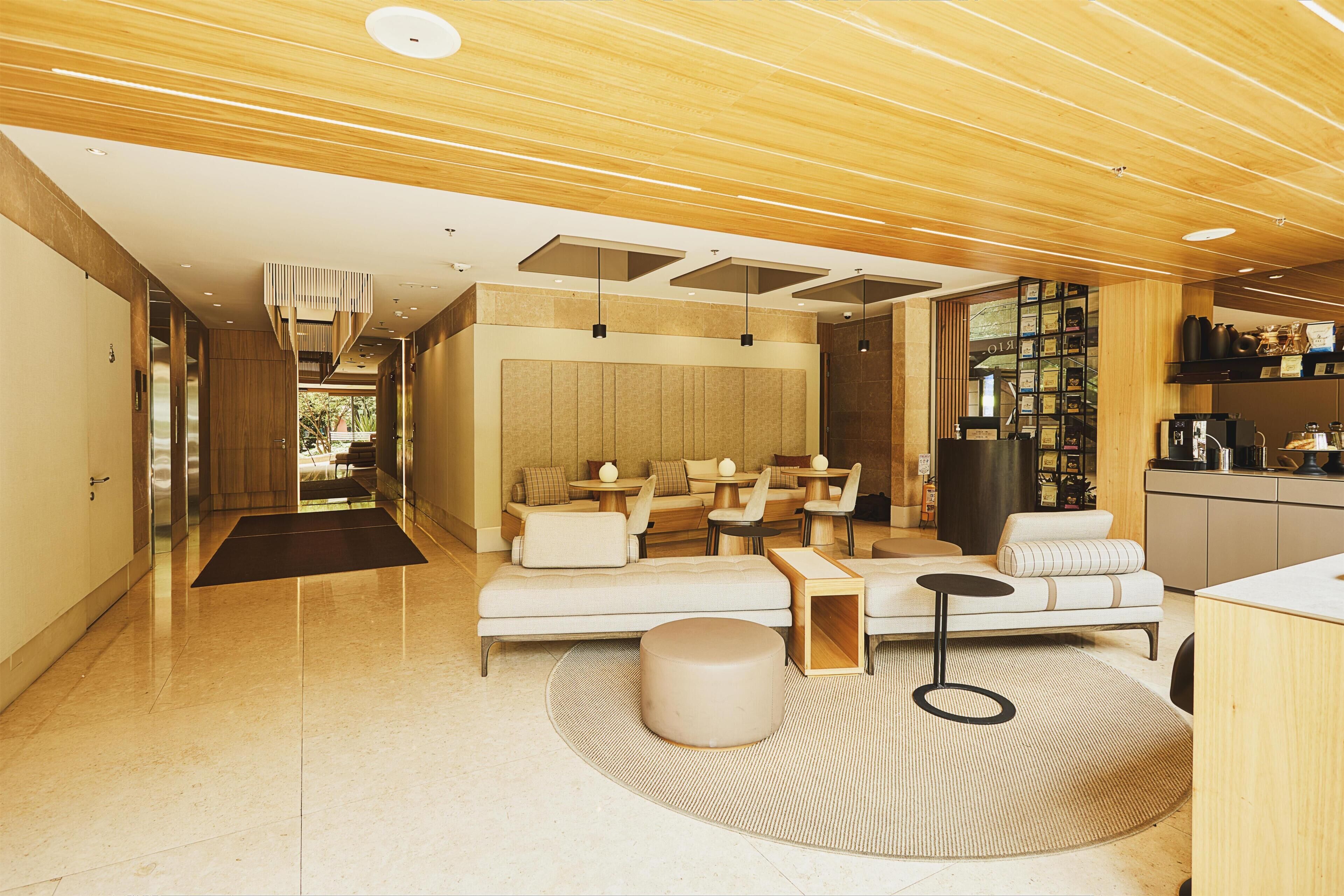 A modern interior with a sofa, round table, and a kitchen area.