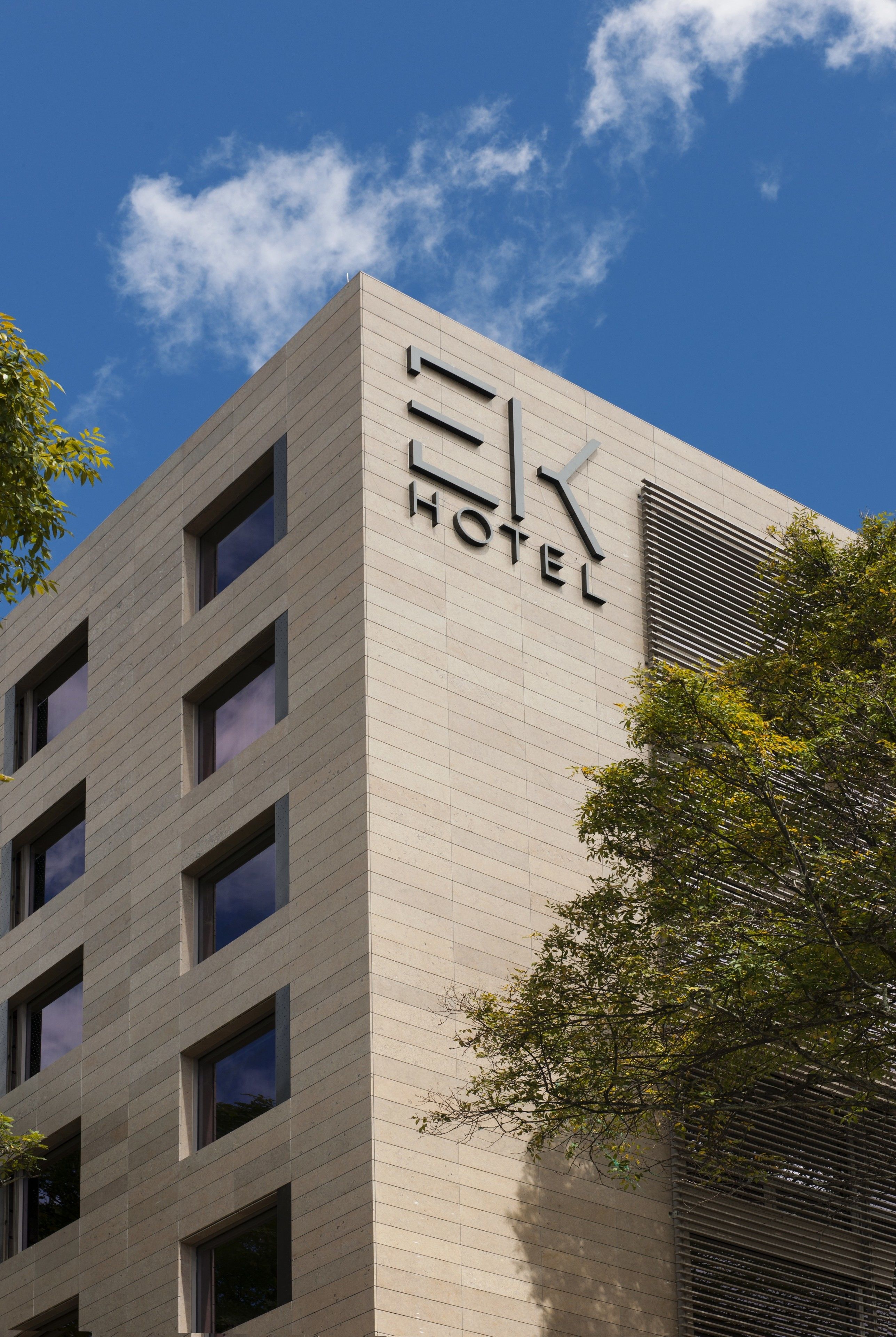 A modern hotel building with a prominent 'HOTEL' sign on the facade.