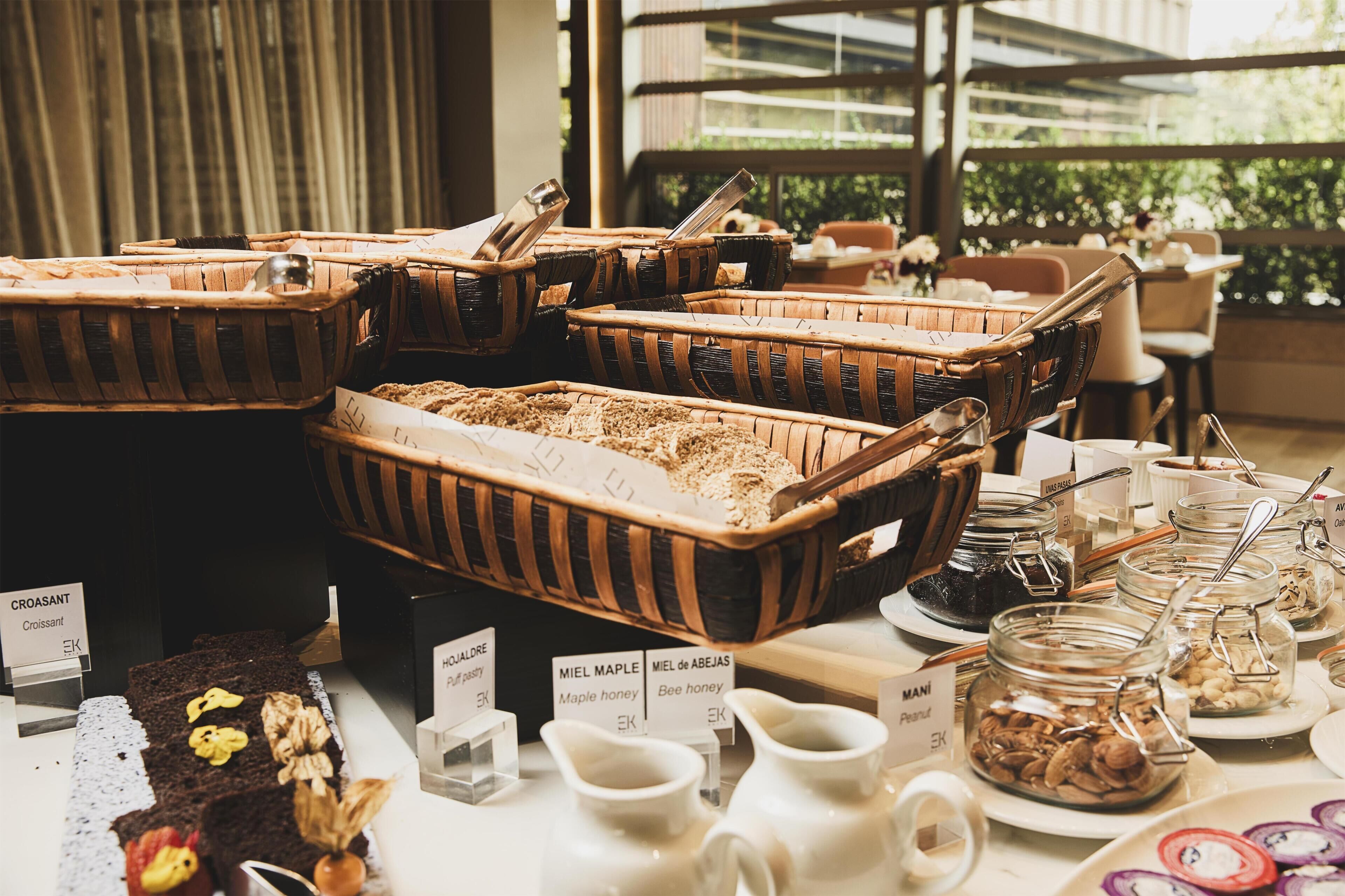 Una mesa de buffet con diversos alimentos y utensilios de servicio.