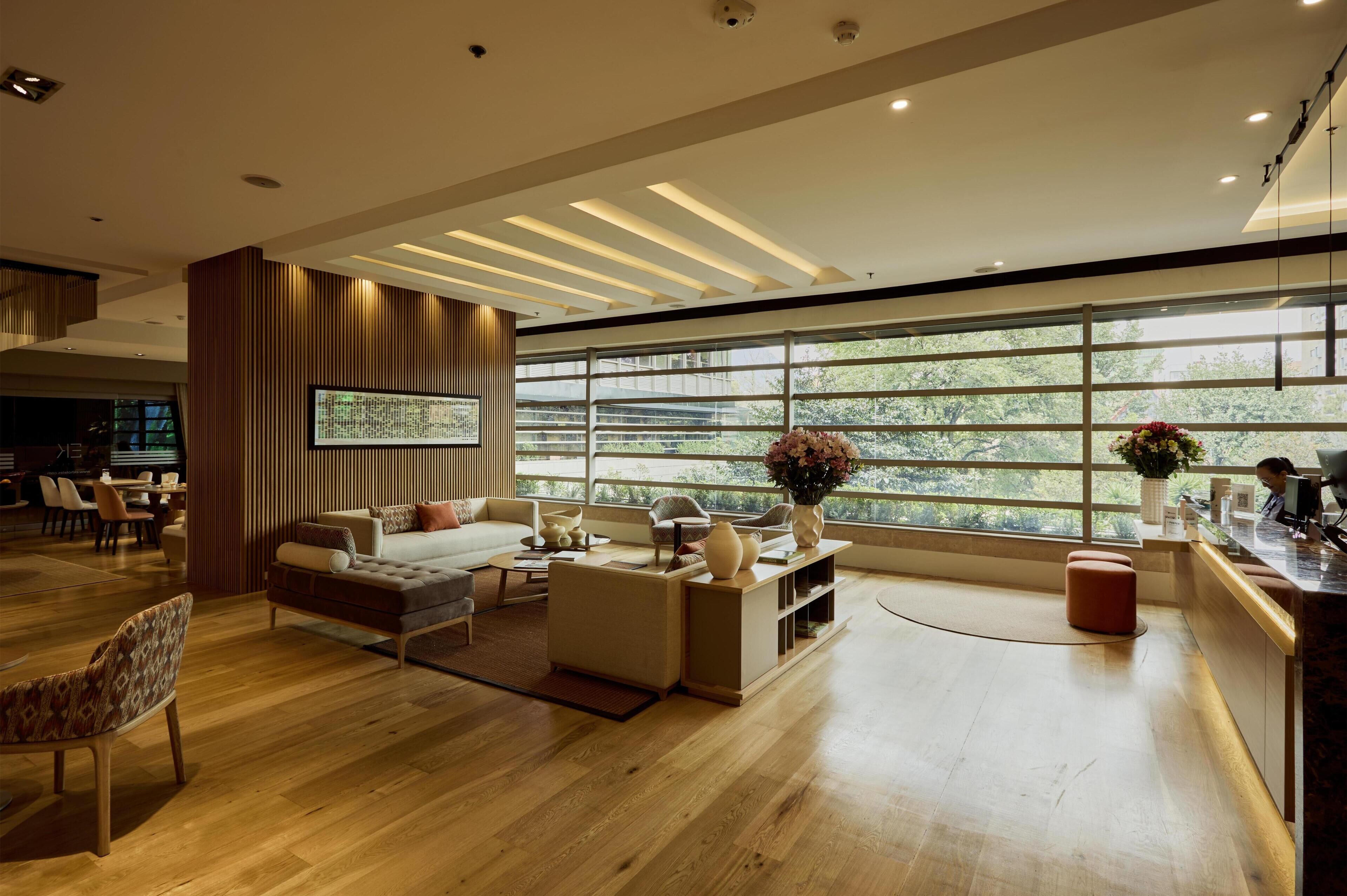 A modern living room with a large window, wooden flooring, and contemporary furniture.