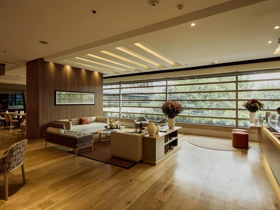 A modern living room with a large window, wooden flooring, and contemporary furniture.