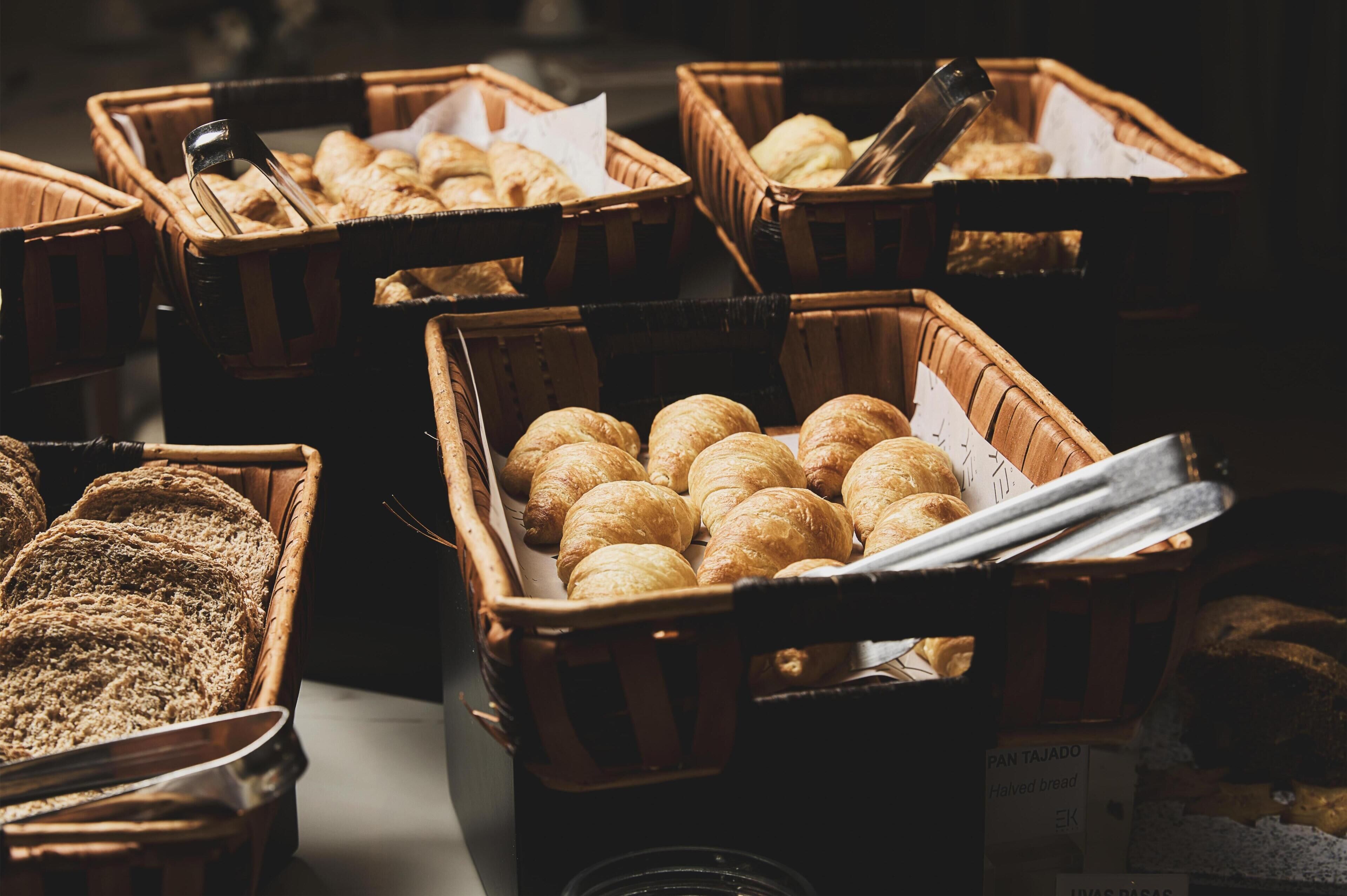 Multiple wicker baskets filled with various baked goods, including bread and pastries.